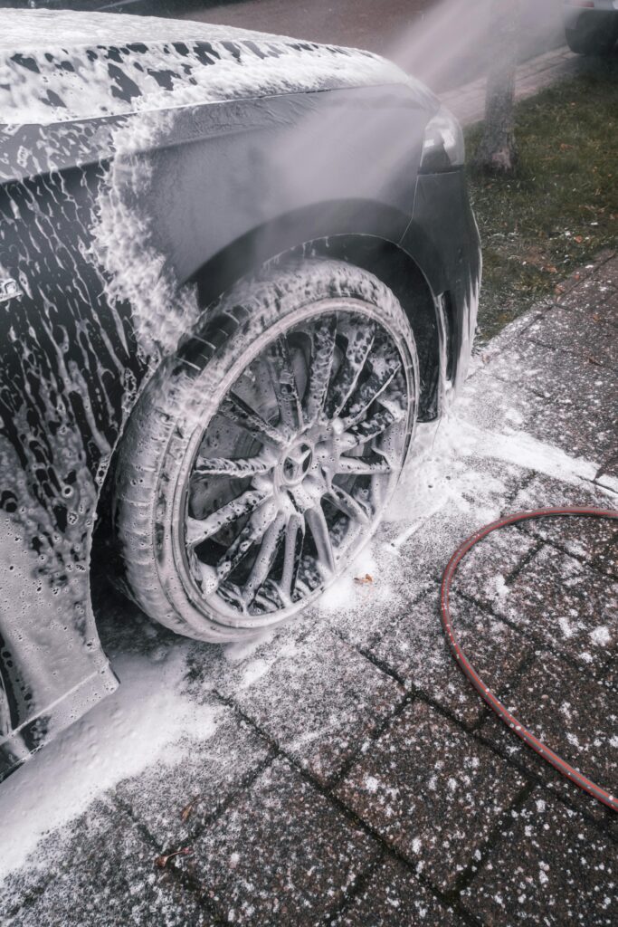 pexels photo 5693651 5693651 Close-up of a luxury car wheel being thoroughly washed with foam outdoors.