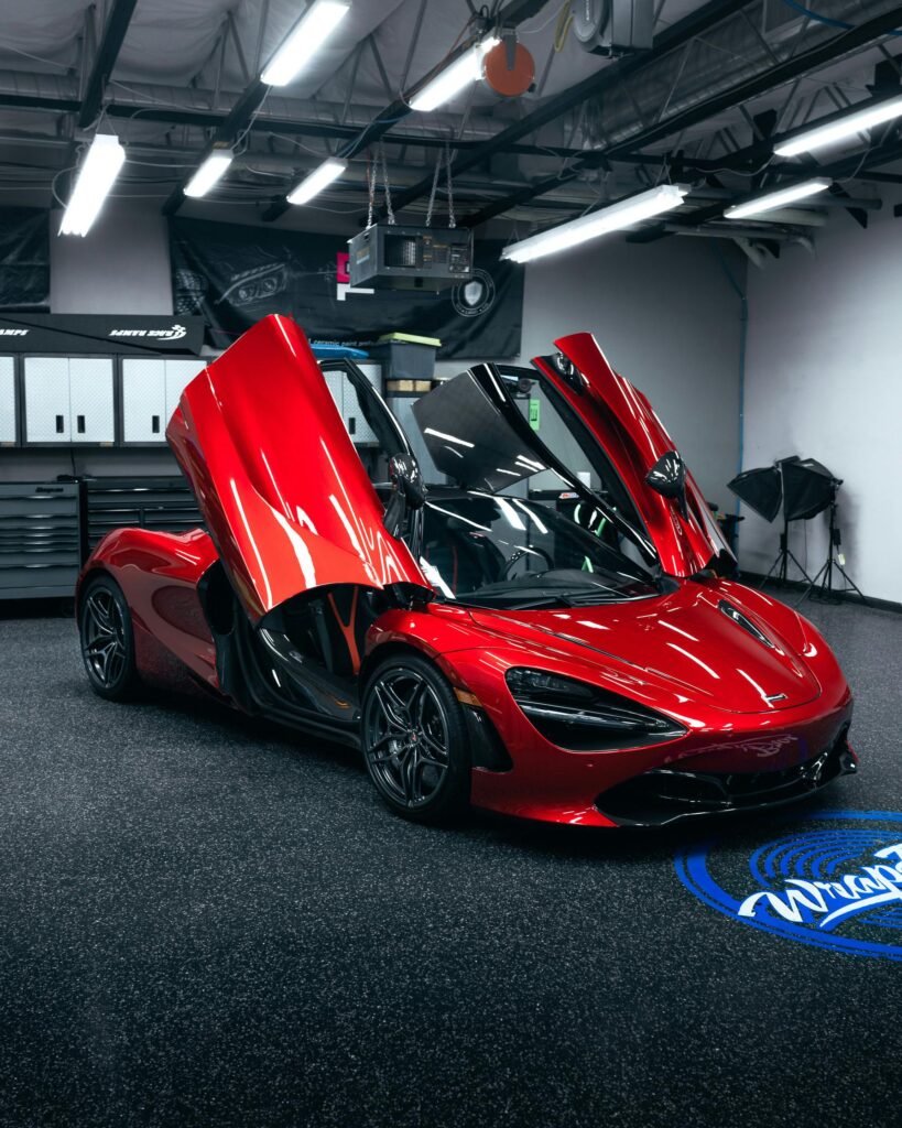 pexels photo 6650819 6650819 A striking red McLaren 720S with sleek design in a well-lit modern garage.
